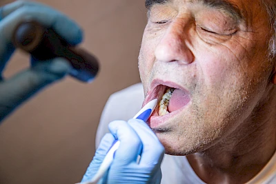 Taschenlampe zur optimalen Ausleuchtung so nah möglich an den Mund heranführen.