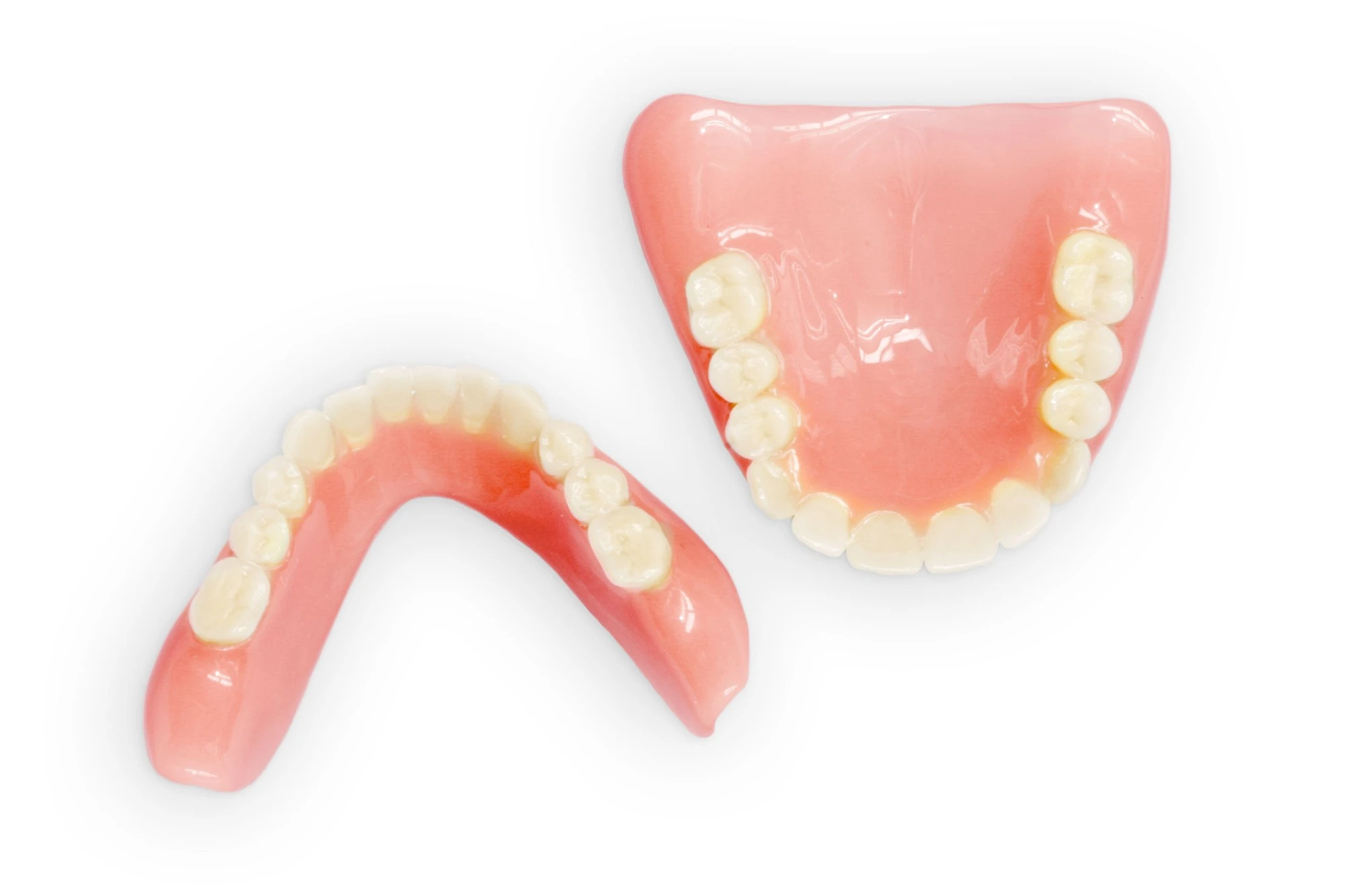 Typische Totalprothesen für den Unterkiefer (links) und Oberkiefer (rechts)
